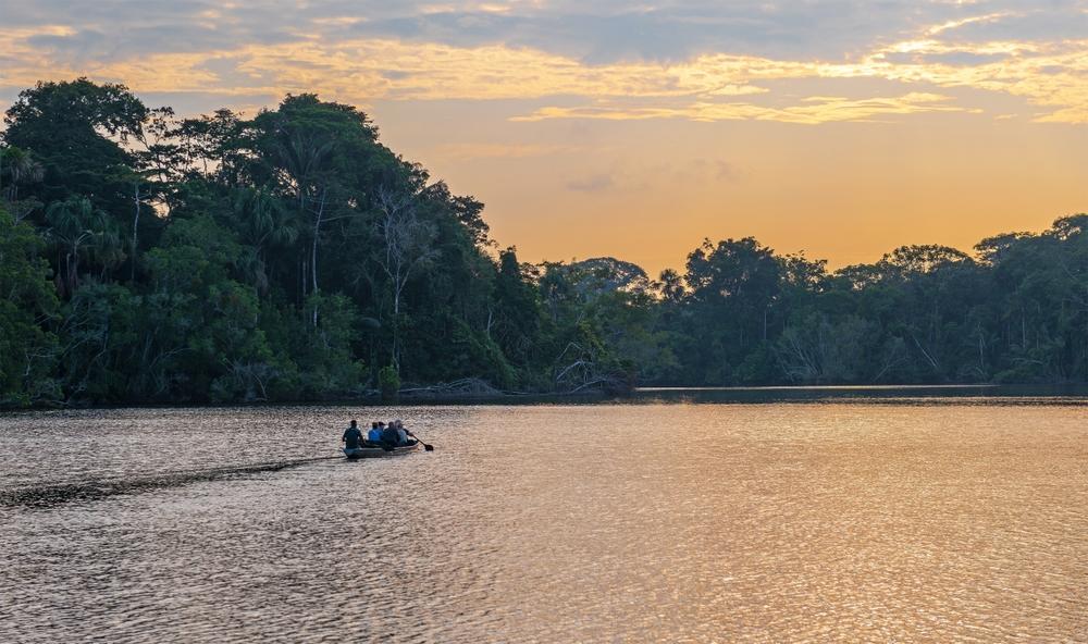 Canoe with tourists departing at dawn, Yasuni National Park, Ecuador