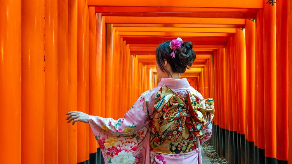 Asian woman in traditional Japanese kimonos at Fushimi Inari Shrine, Kyoto, Japan