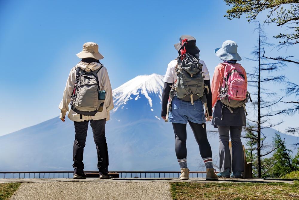 Three hikers looking at Mount Fuji, Japan