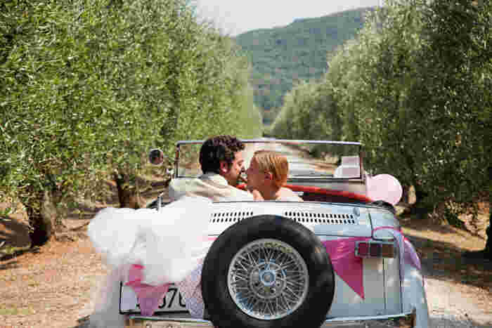 Newlyweds kissing in classic car southern italy honeymoon