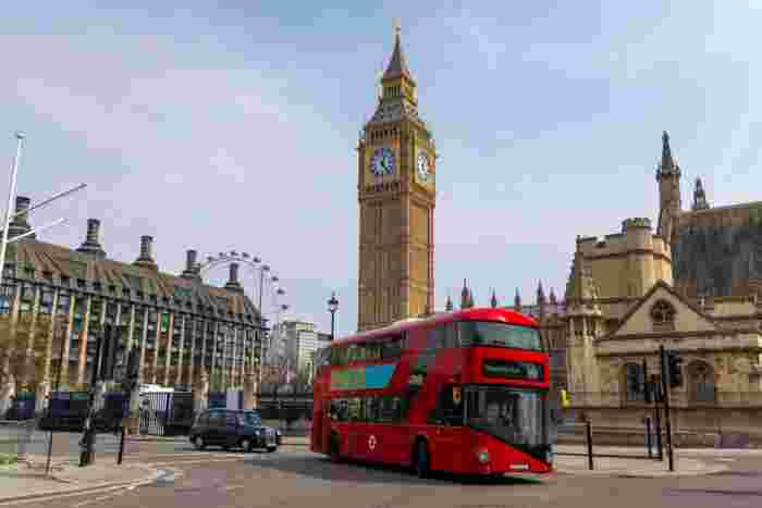 image A red double-decker bus passing in front of Big Ben and the Houses of Parliament in Westminster, London.