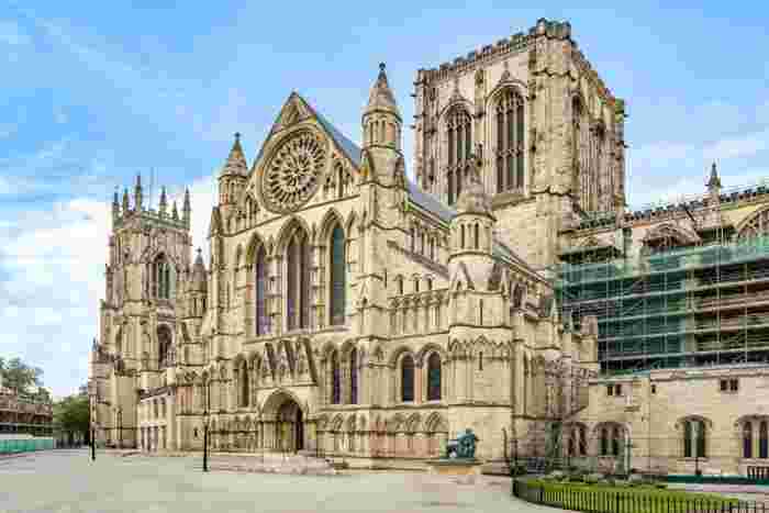 image The Gothic south transept of York Minster with its rose window and ornate stone carvings, partially covered in restoration scaffolding.