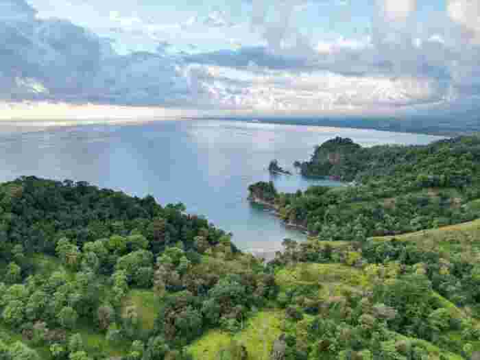 Coastal rainforest and small islands in Manuel Antonio with calm ocean and cloudy sky