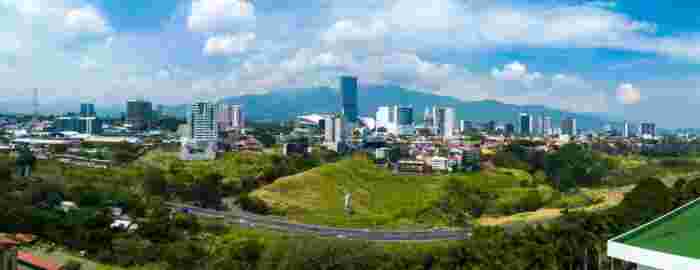 Panoramic view of San José skyline with modern buildings and mountains in the background