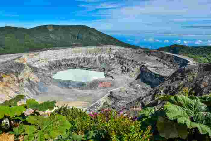 Crater of Poás Volcano with a steaming lake surrounded by rugged terrain