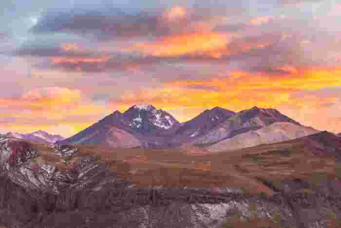 Dramatic sunset over the Andes Mountains in Mendoza Province, Argentina, with snow-capped peaks and colorful alpine landscape 