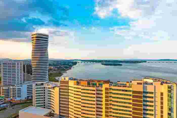 Modern skyline and riverside waterfront of Guayaquil, Ecuador, during golden hour with high-rise buildings and the Guayas River 