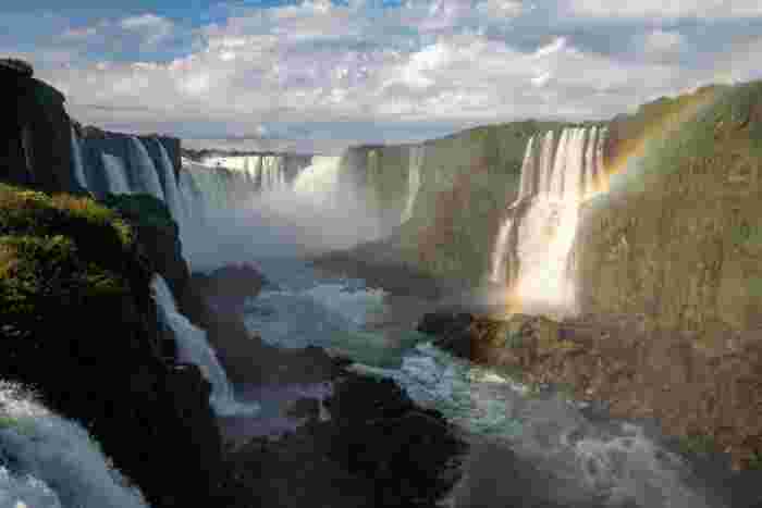 Iguazu Falls with rainbow and lush subtropical rainforest in Argentina
