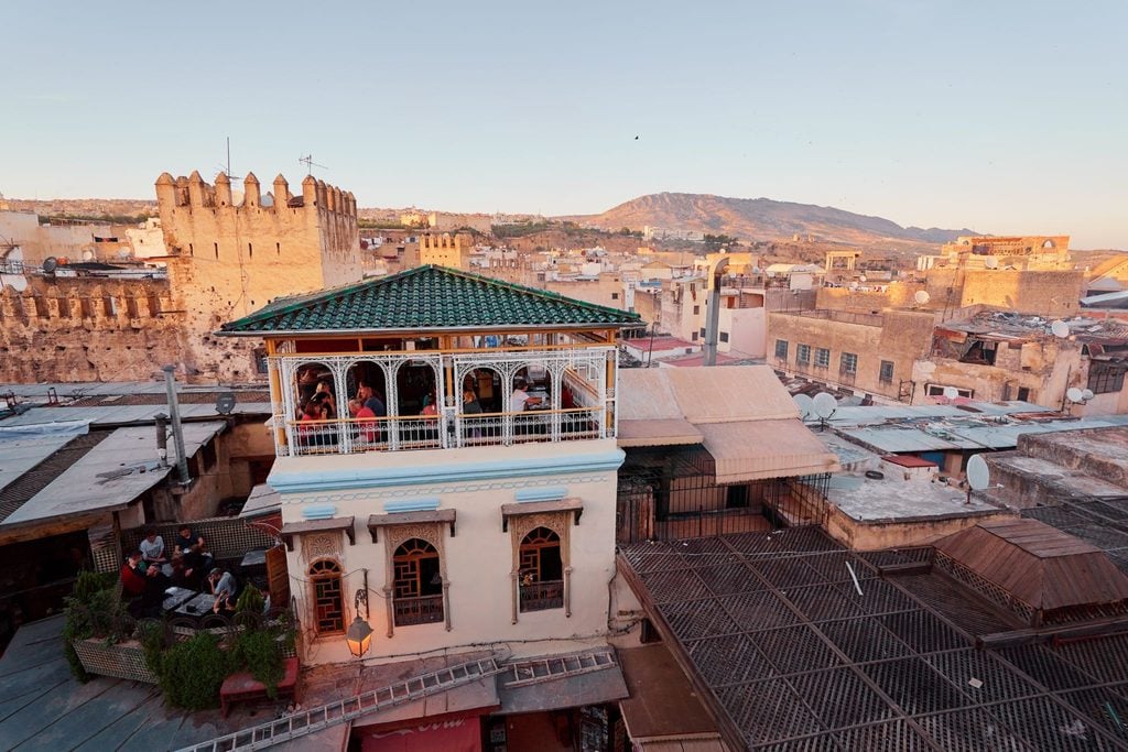 Rooftop terrace overlooking the ancient walled medina of Fez at sunset 