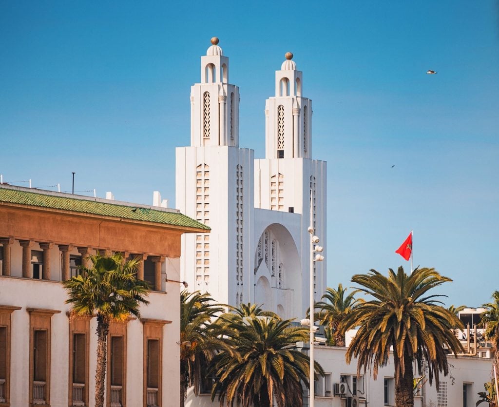 Twin minarets of a mosque rising above palm trees in Casablanca 