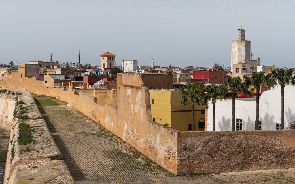 Ancient fortress ramparts and a mosque minaret overlooking a Moroccan town 