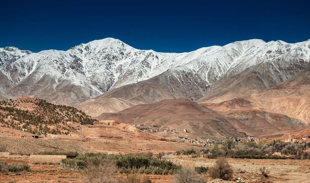 Snow-capped Atlas Mountains rising above a dry valley in Morocco 